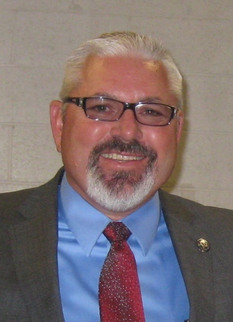 Chief Probation Officer Jeff Thomson wearing a grey suit, blue shirt, and red tie. 