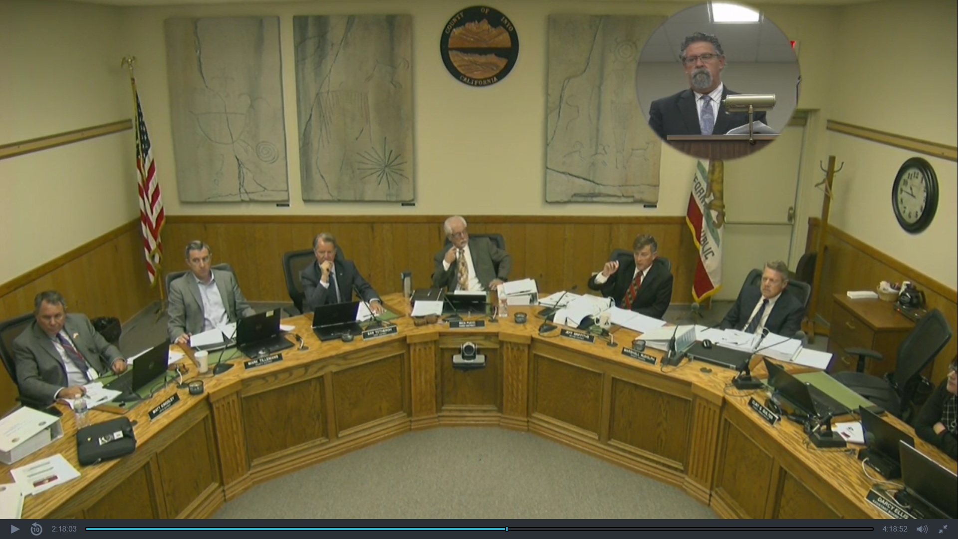 Screenshot of Board of Supervisors meeting, showing five Board members seated at dais along with County Counsel, while CAO speaks from podium, as seen in upper right hand corner.