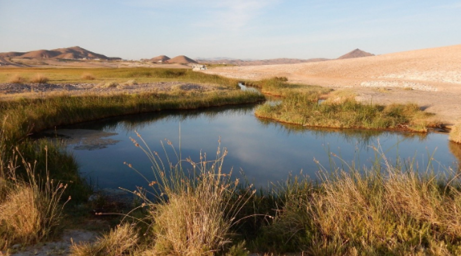 A small river meanders through a desert landscape.