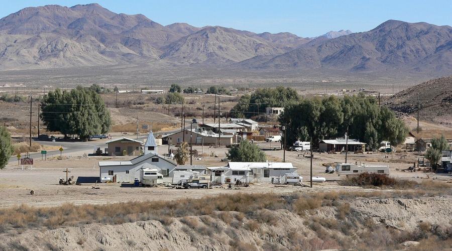 White and beige older buildings set against an arid landscape