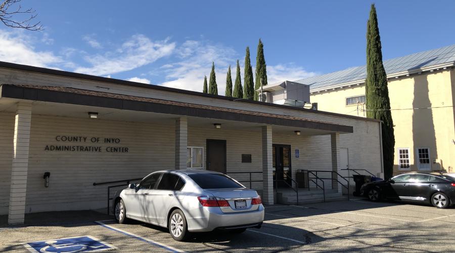 Building with two cars parked in front of it