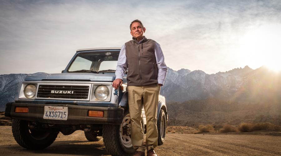 Man standing next to truck in front of Sierra/Alabama Hills