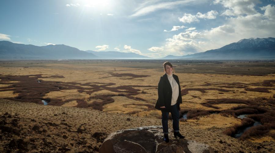 woman standing on rock with valley below