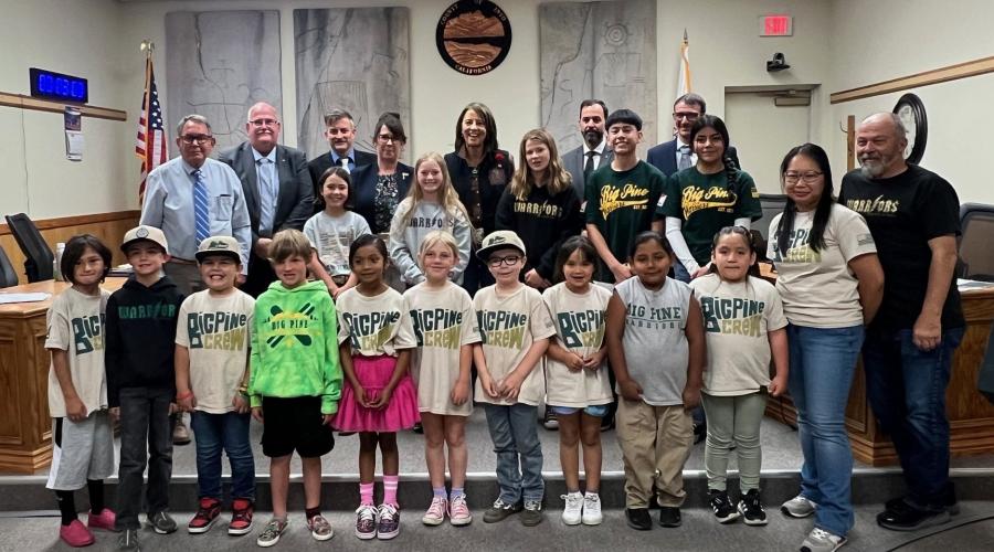 Members of the Board of Supervisors stand behind a contingent of youth from Big Pine Schools.