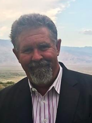 Clint Quilter Headshot outside with mountains in background