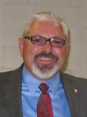 Chief Probation Officer Jeff Thomson wearing a grey suit, blue shirt, and red tie. 